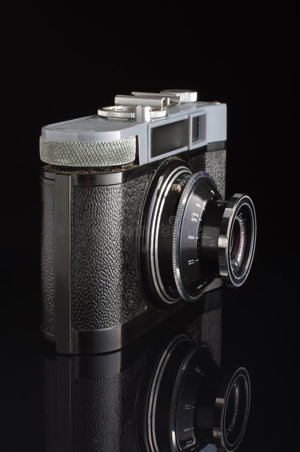 Obsolete Film Camera Isolated on the Dark Background with Reflection