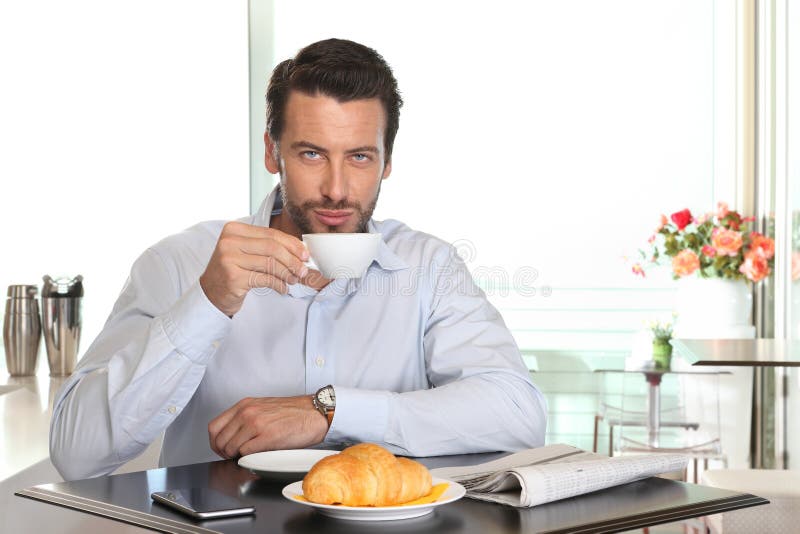 Obsługuje pić kawę w kawiarni z croissant i gazetą na tabl obrazy royalty free Obsługuje pić kawę w kawiarni z croissant i gazetą na tabl obrazy royalty free