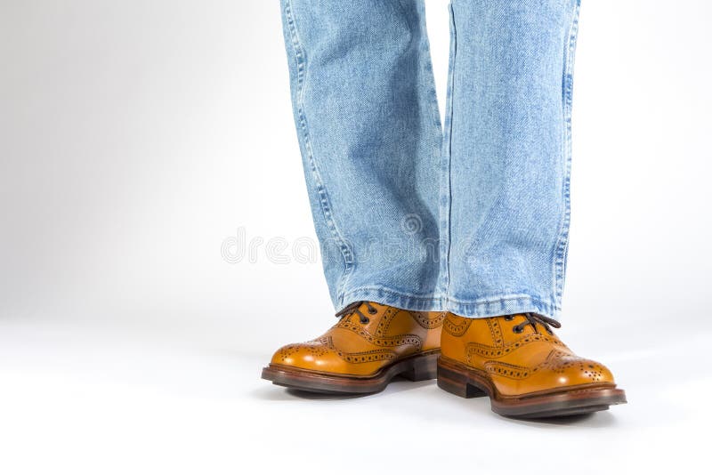 Obuwia poj?cie Zbliżenie Frontowy widok mężczyzna nogi w Brown Brogue Oksfordzkich butach Pozować w niebieskich dżinsach Przeciw obrazy stock Obuwia poj?cie Zbliżenie Frontowy widok mężczyzna nogi w Brown Brogue Oksfordzkich butach Pozować w niebieskich dżinsach Przeciw obrazy stock