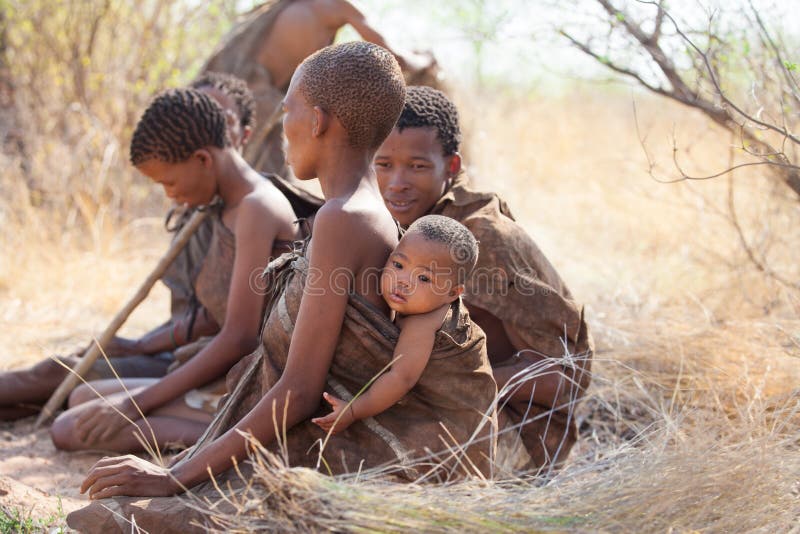 Kalahari, Botswana-October 16 2011. Group of Bushmen sitting on the ground around a bonfire on October 16, 2011 in Kalahari desert of Botswana. Kalahari, Botswana-October 16 2011. Group of Bushmen sitting on the ground around a bonfire on October 16, 2011 in Kalahari desert of Botswana.