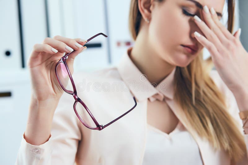 Occhiali caucasici stanchi della tenuta della donna di affari e massaggiare il ponte del naso Disagio di sensibilità della ragazz immagine stock libera da diritti Occhiali caucasici stanchi della tenuta della donna di affari e massaggiare il ponte del naso Disagio di sensibilità della ragazz immagine stock libera da diritti