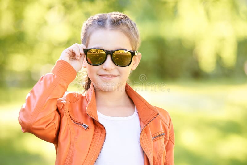 Occhiali neri rivestimento di colore sulla via stile di vita teenager di fascino castana femminile della roccia funky adolescente fotografia stock Occhiali neri rivestimento di colore sulla via stile di vita teenager di fascino castana femminile della roccia funky adolescente fotografia stock