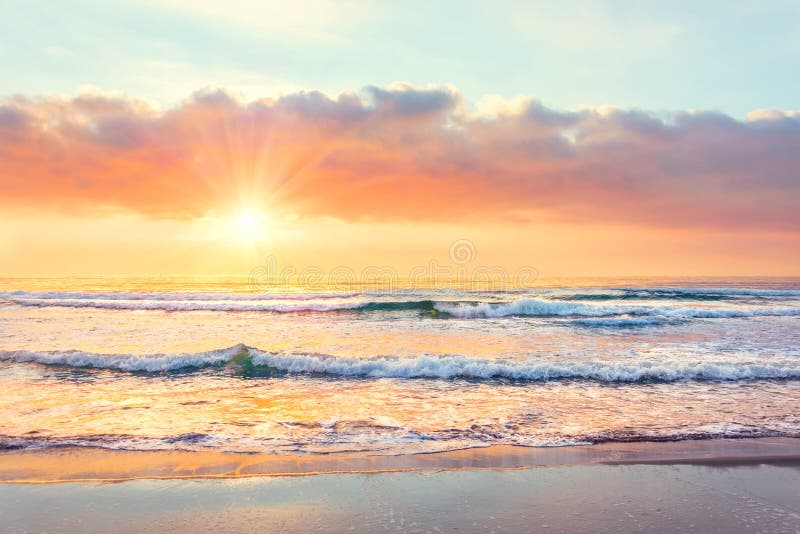 Oceaangolf op het strand in zonsondergangtijd, zonstralen