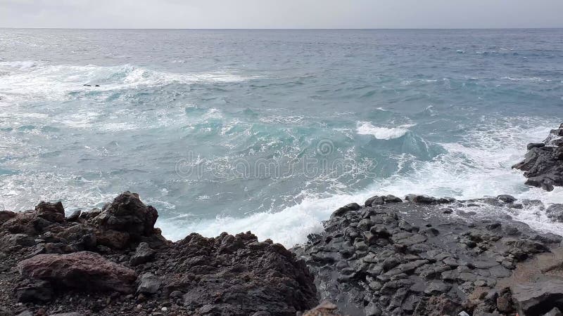 Oceaangolven op tenerife over lavapijten