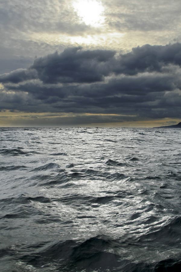 Océano ondas sobre el bullicioso el cielo, nubes encendido paquete.