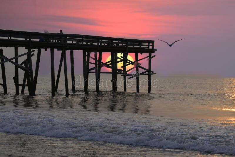 An Enhance Sunrise Shines through the Beach Fishing Pier on Amelia