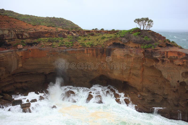 Stormy waves eroding high cliff Australian landscape