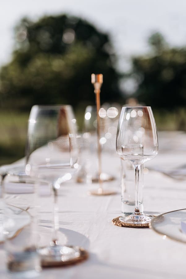 Ochelari de vin eleganți și de masă pe o masă de exterior acoperită cu o linie albă stock photo