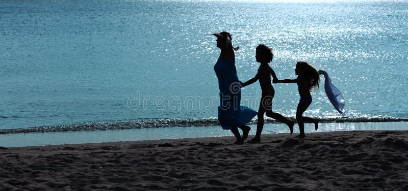 Ochtendoefening - vrouw en jonge geitjes die op het strand lopen stock afbeeldingen Ochtendoefening - vrouw en jonge geitjes die op het strand lopen stock afbeeldingen