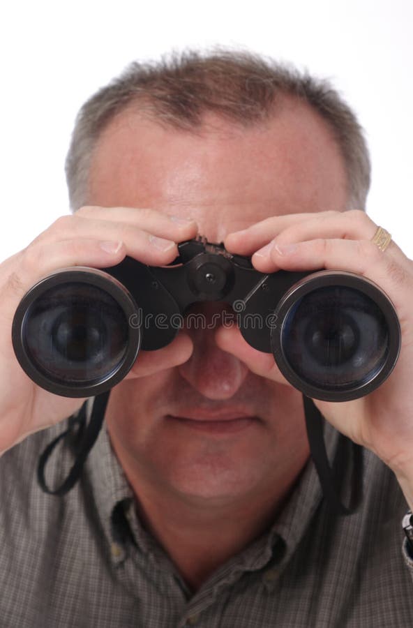 Man looking through binoculars with eyes visible in lens; isolated on white with focus on end of binoculars; see two other versions, one normal, one with magnified cartoon eyes in lenses. Man looking through binoculars with eyes visible in lens; isolated on white with focus on end of binoculars; see two other versions, one normal, one with magnified cartoon eyes in lenses