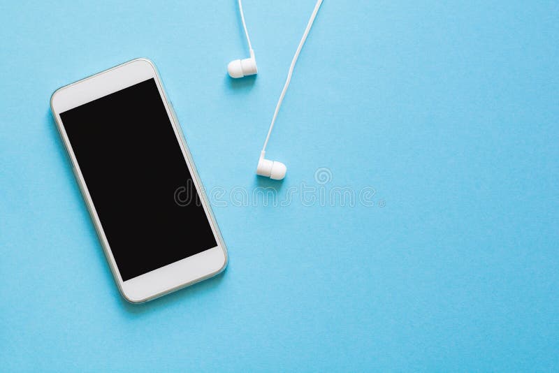 Odgórnego widoku egzaminu próbnego słuchawki na błękitnym tle i smartphone Mieszkanie nieatutowy obrazy stock Odgórnego widoku egzaminu próbnego słuchawki na błękitnym tle i smartphone Mieszkanie nieatutowy obrazy stock