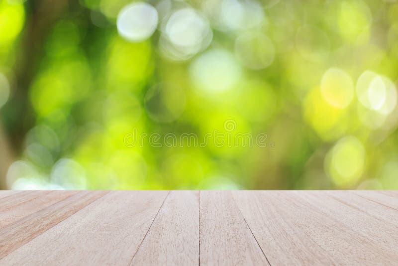 Odgórny drewniany stół z pogodnym abstrakt zieleni natury tłem, bl zdjęcia stock