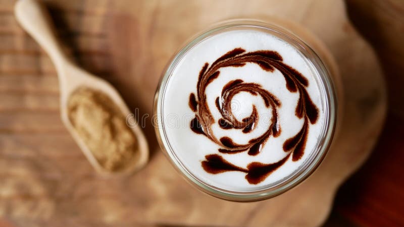 Odgórny widok gorącej mokki latte kawowej sztuki kształta spirali czekoladowy kierowy szkło na stołowym tle, rocznika styl