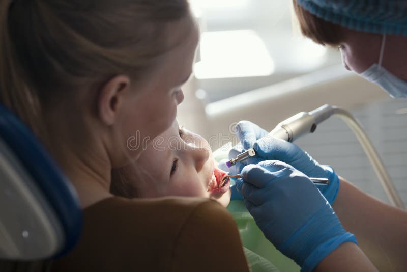 Odontologia de crianças - dentista e menina com mamã imagens de stock royalty free Odontologia de crianças - dentista e menina com mamã imagens de stock royalty free
