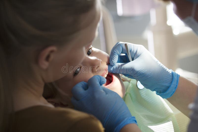 Odontologia de crianças - dentista e menina com mamã fotografia de stock Odontologia de crianças - dentista e menina com mamã fotografia de stock