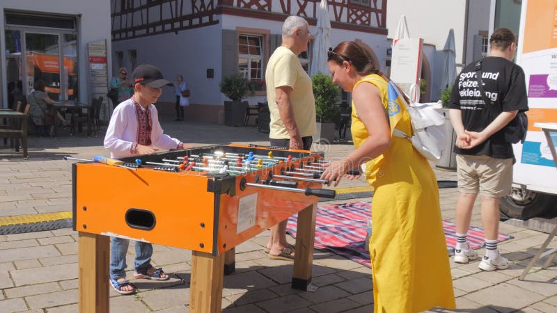 Offenburg allemagne 24 juin 2023 : maman et son fils jouent au baby-foot à l'extérieur sous le ciel ouvert. jeux pour enfants