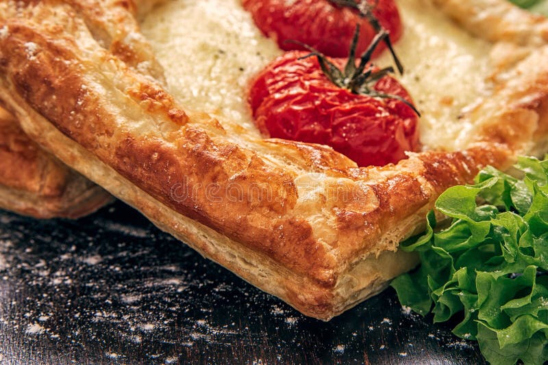 Offene Torte vom Blätterteig mit Käse und Tomaten mit Kopfsalatblättern stockfoto Offene Torte vom Blätterteig mit Käse und Tomaten mit Kopfsalatblättern stockfoto