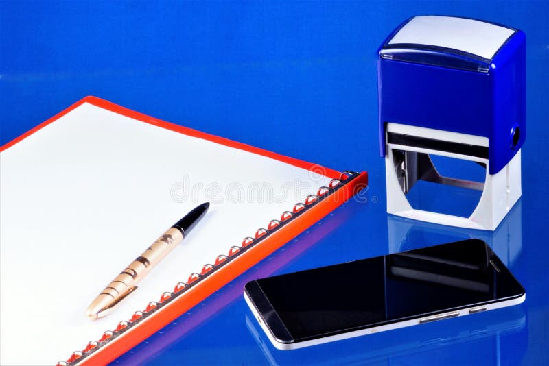Office accounting desktop, blue background, with the necessary accessories. Folder with documents, smartphone Communicator for stock images Office accounting desktop, blue background, with the necessary accessories. Folder with documents, smartphone Communicator for stock images