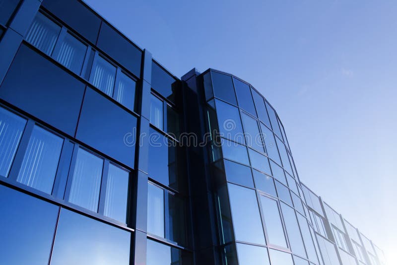 Angolato colpo di un edificio per uffici con brillante blu facciata in vetro, in una giornata di sole.
