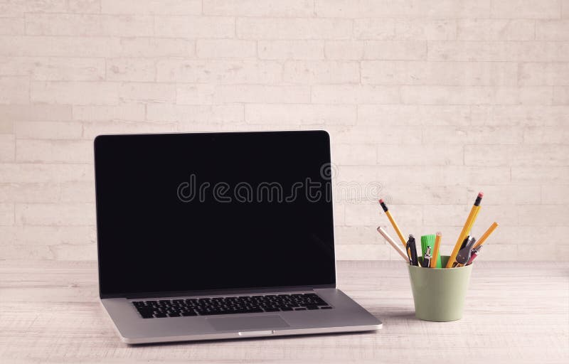 Office desk closeup with white brick wall