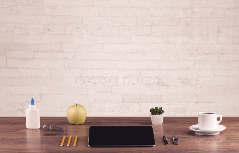 Office desk closeup with white brick wall