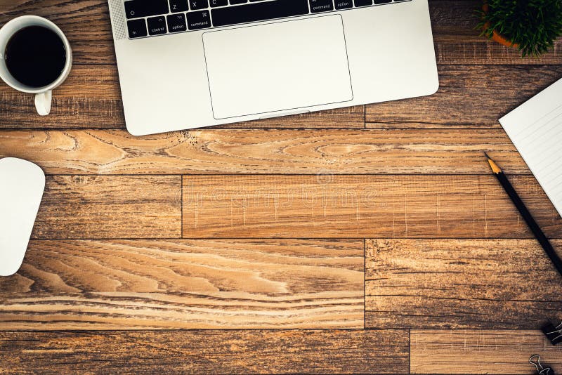 The office desk flat lay view with laptop, mouse, tree, black clip, coffee cup, notebook, pencil on wood texture background