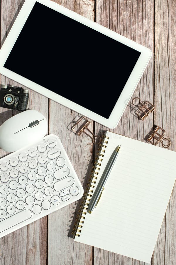 Office desk mock up template with tablet, keyboard, computer mouse and coffee on wooden background stock image