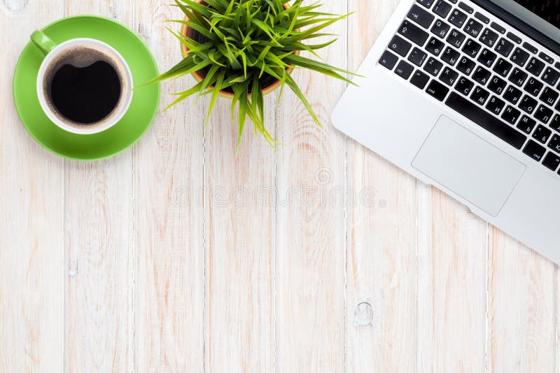 Büro-Schreibtisch, Tisch mit laptop, Kaffeetasse und Blumen.