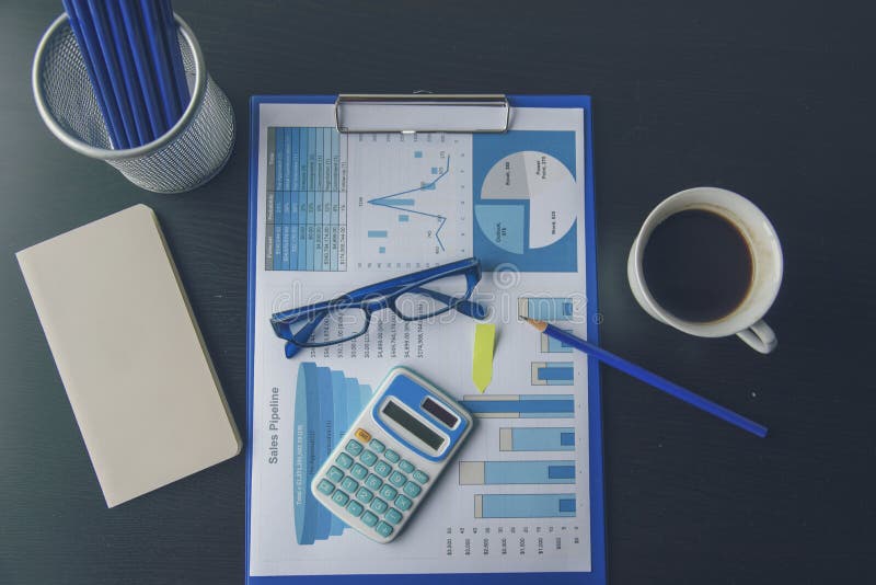 Office laptop business financial document chart and graph on wooden table with coffee cup. Flat lay notebook computer laptop on stock photo