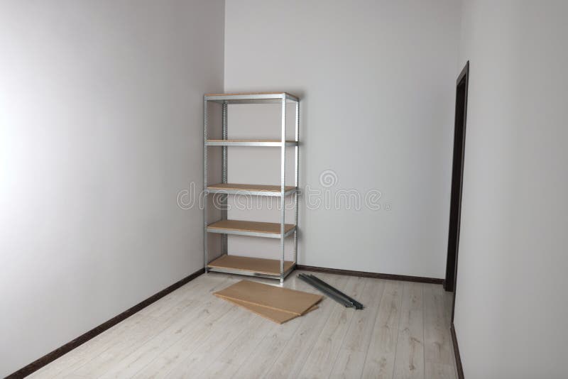 Office Room with White Walls and Metal Storage Shelf Stock Image
