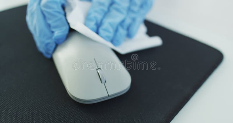 Office sanitizing wipe wiping mouse and mousepad with disinfecting wipes. Coronavirus COVID-19 sanitize cleaning