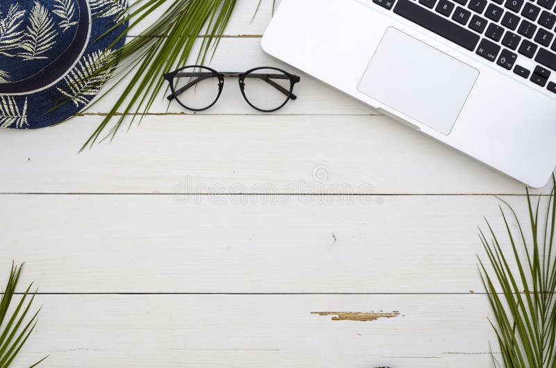 Office table desk, Flatlay, topview. Palm branches laptop keyboard and summer hat. Frame with copy space. Mockup template