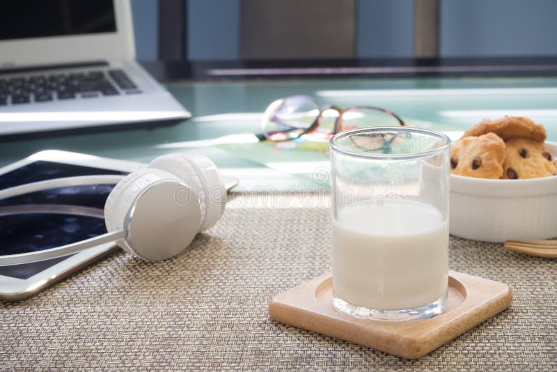 Office table with glasses of milk, dessert and office supply stock images Office table with glasses of milk, dessert and office supply stock images