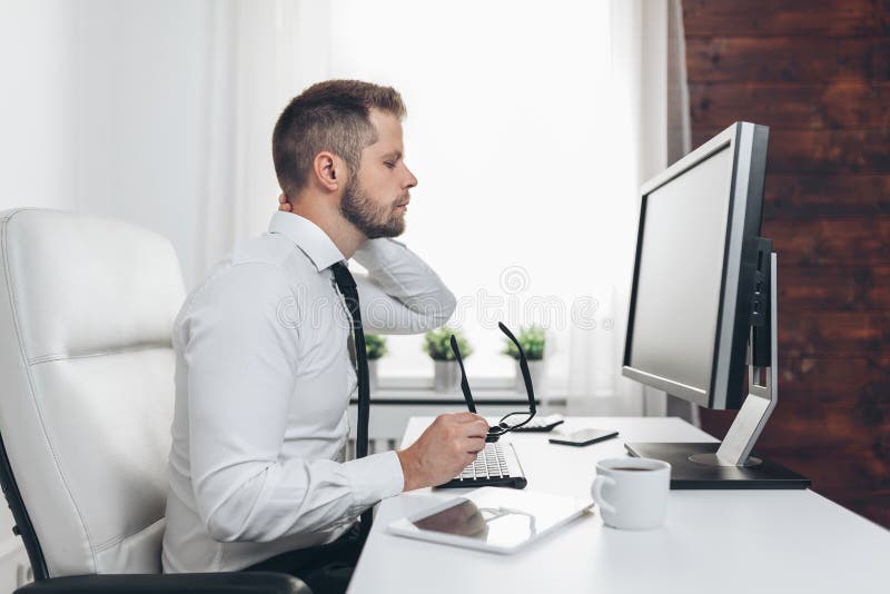 Office Worker With Pain From Sitting At Desk All Day Stock Photo