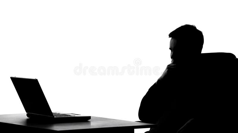 Office worker silhouette thinking about business project in front of laptop pc, stock photo