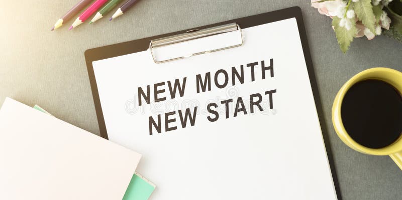 Coffee cup, calculator, stationery and plant. Text NEW MONTH NEW START on white notepad page. Table desk top royalty free stock image