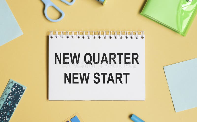 Coffee cup, calculator, stationery and plant. Text NEW MONTH NEW START on white notepad page. Table desk top stock image