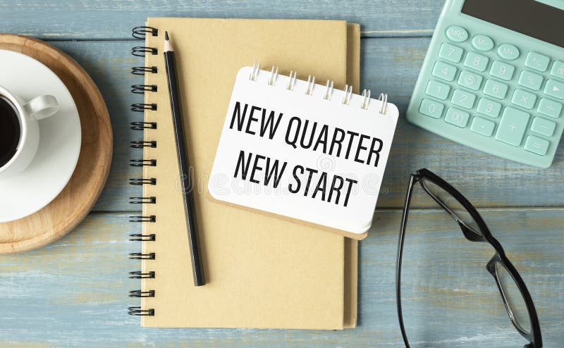 Office workplace with coffee cup, calculator, stationery and plant. Text NEW MONTH NEW START on white notepad page. stock photo