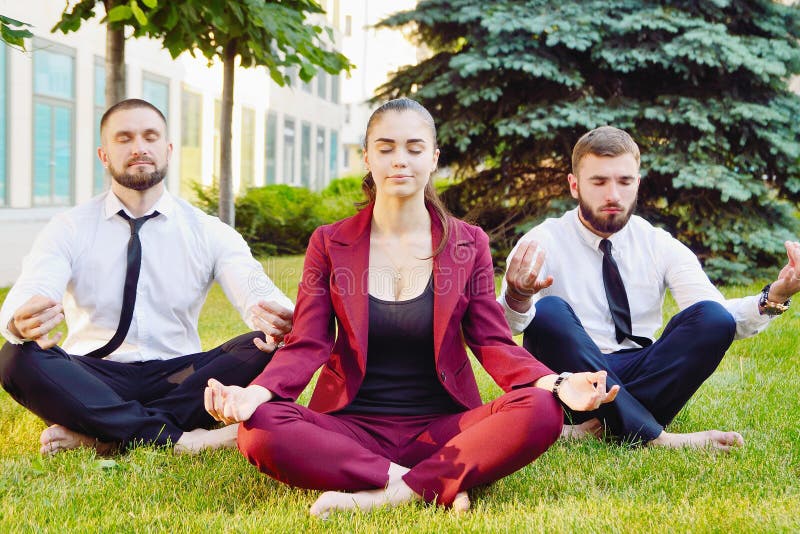 Office yoga. Three young employees in a lotus pose are sitting o royalty free stock images Office yoga. Three young employees in a lotus pose are sitting o royalty free stock images