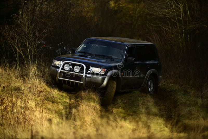 Offroad ras op de achtergrond van de dalingsaard SUV of offroad auto in sleur wordt geplakt die Autorennen in de herfst bosuiters stock afbeelding Offroad ras op de achtergrond van de dalingsaard SUV of offroad auto in sleur wordt geplakt die Autorennen in de herfst bosuiters stock afbeelding