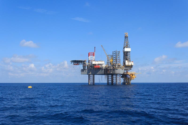 Offshore Jack Up Drilling Rig Over the Production Platform Stock Photo