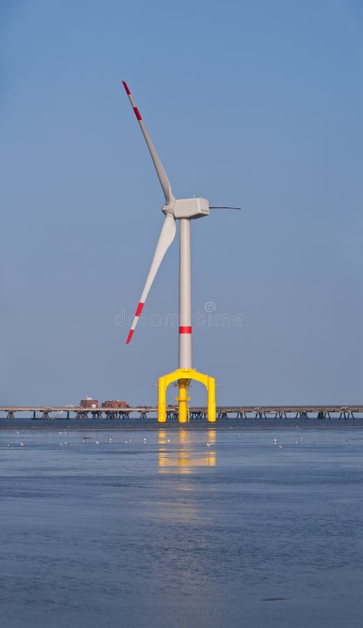 Offshore wind turbine with yellow base.