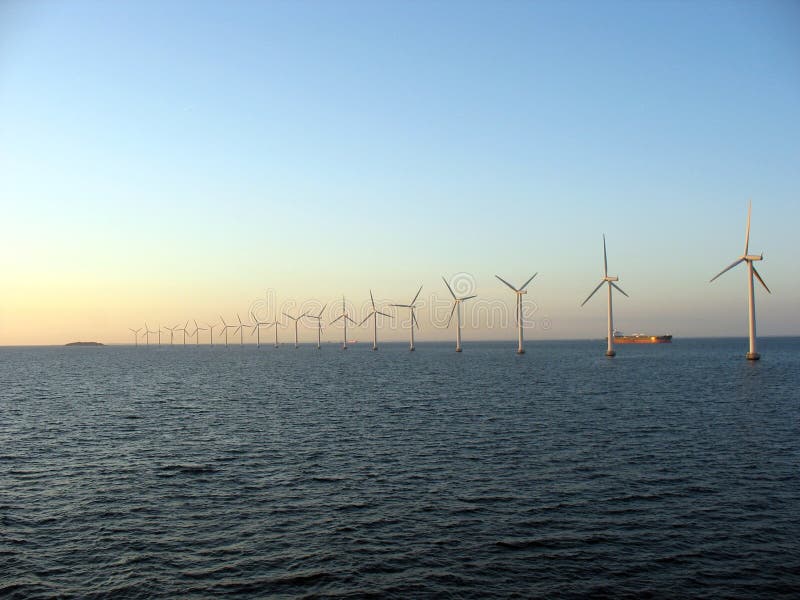 Offshore windfarm near Copenhagen, Denmark on a sunset - long line till horizon with ship visible. Offshore windfarm near Copenhagen, Denmark on a sunset - long line till horizon with ship visible