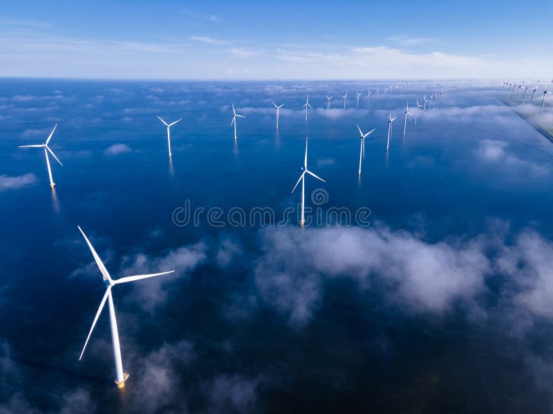 offshore windmill park with clouds and a blue sky, windmill park in the ocean aerial view with wind turbine Flevoland Netherlands Ijsselmeer. Green energy. offshore windmill park with clouds and a blue sky, windmill park in the ocean aerial view with wind turbine Flevoland Netherlands Ijsselmeer. Green energy