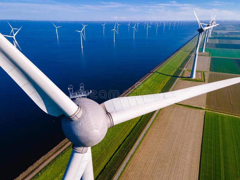 offshore windmill park with clouds and a blue sky, windmill park in the ocean aerial view with wind turbine Flevoland Netherlands Ijsselmeer. Green energy. offshore windmill park with clouds and a blue sky, windmill park in the ocean aerial view with wind turbine Flevoland Netherlands Ijsselmeer. Green energy