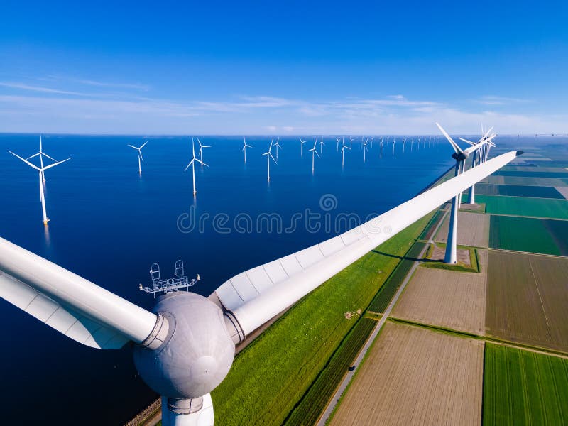 offshore windmill park with clouds and a blue sky, windmill park in the ocean aerial view with wind turbine Flevoland Netherlands Ijsselmeer. Green energy. offshore windmill park with clouds and a blue sky, windmill park in the ocean aerial view with wind turbine Flevoland Netherlands Ijsselmeer. Green energy