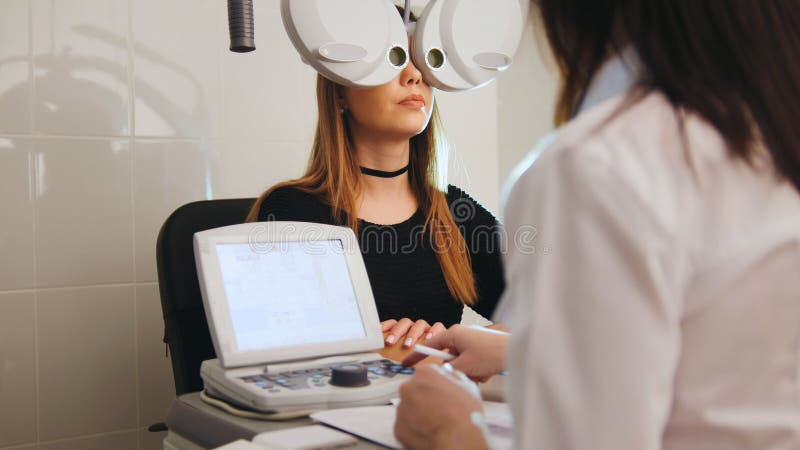 Oftalmologi - begrepp för ögonklinik - optometriker och patient som gör examenvision royaltyfria foton Oftalmologi - begrepp för ögonklinik - optometriker och patient som gör examenvision royaltyfria foton