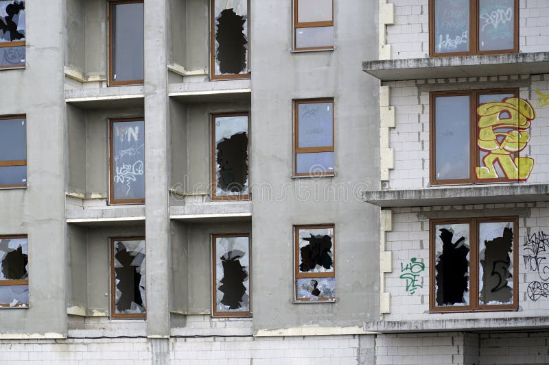Ofärdig bostadsbyggnad med brutna fönster, övergivna fastighetsprojekt arkivbilder