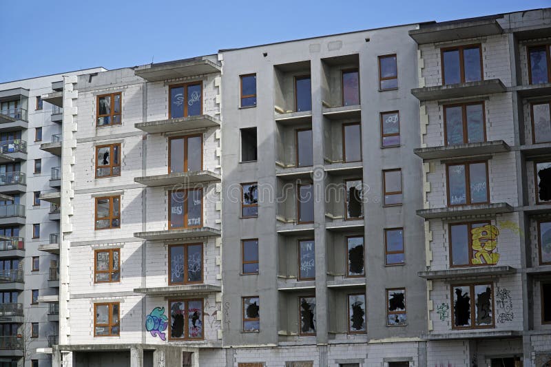 Ofärdig bostadsbyggnad med brutna fönster, övergivna fastighetsprojekt royaltyfri fotografi