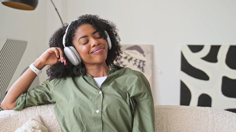 Ogen gesloten en met serene expressie geniet de vrouw van een moment van ontspanning met haar hoofdtelefoon